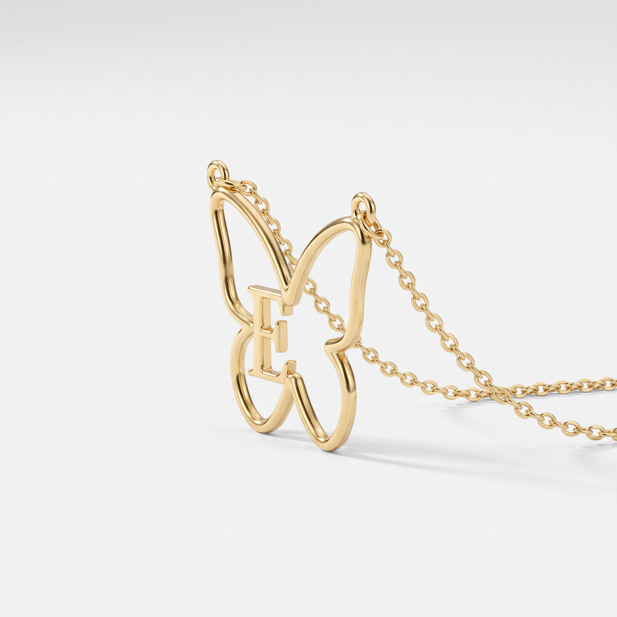 Gold butterfly necklace with initial E, an open butterfly pendant personalized with a letter on a dainty cable chain