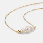 14K gold pearl necklace with three graduated pearls between gold beads on a dainty cable chain