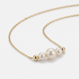 14K gold pearl necklace with three graduated pearls between gold beads on a dainty cable chain
